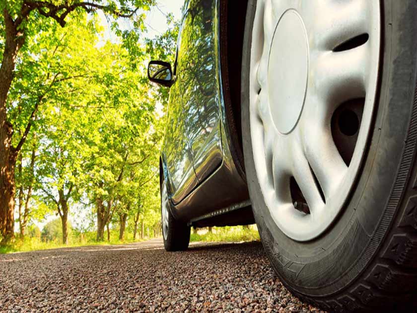 summer changeover services from Tireland Heavy Duty Automotive. Their image shows a tire with some on the threads and is on a road with sunlight on the trees which looks like a summer's day in Kelowna